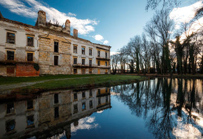 Reflection of building in lake against sky