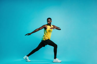 Man exercising against blue background