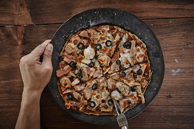 Cropped hand of person holding pizza