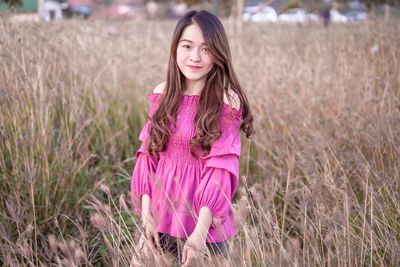 Portrait of a smiling girl standing on field