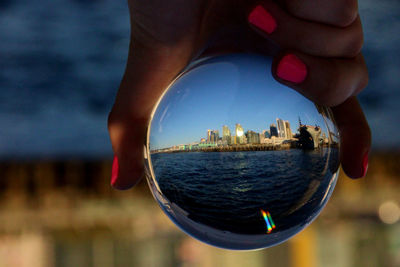 Low section of woman holding crystal ball