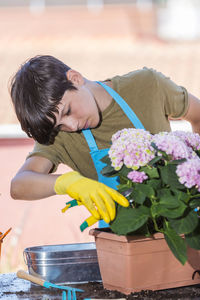 Teenager boy gardening in garden