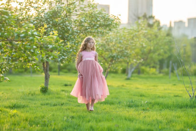 Woman standing on grass against trees