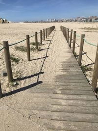 Wooden posts on beach against sky