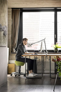 Side view of man working on table
