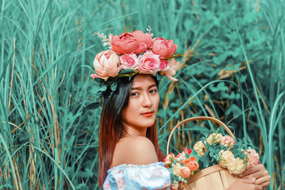 Portrait of woman against pink roses