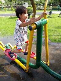 Boy playing on outdoor play equipment at playground