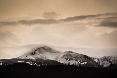 Scenic view of mountains against cloudy sky