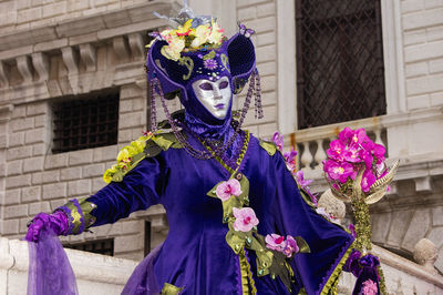 Midsection of man standing on purple flowers