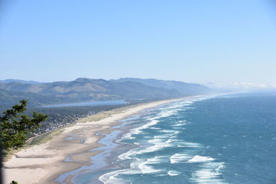 Scenic view of beach against clear blue sky