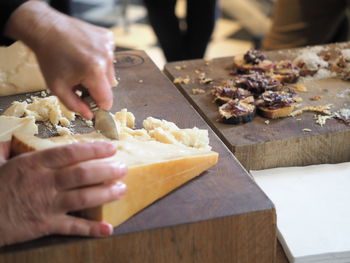 Midsection of person preparing food on cutting board