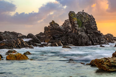 Rock formation in sea against sky