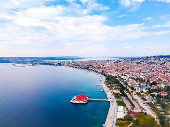 High angle view of sea by buildings in city against sky