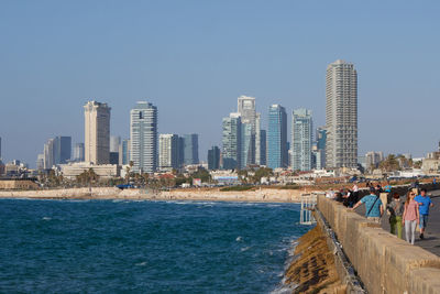 City at waterfront against clear sky