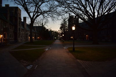 Illuminated walkway in city at night