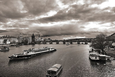View of boats in river against cloudy sky