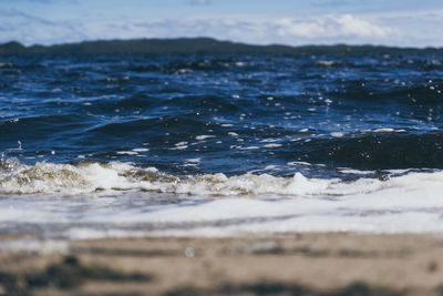 Close-up of wave on beach against sky