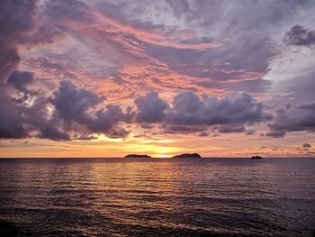 Scenic view of sea against dramatic sky during sunset