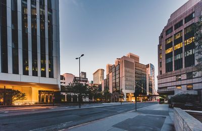 Street amidst buildings against sky at dusk