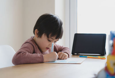 Boy sitting on table at home