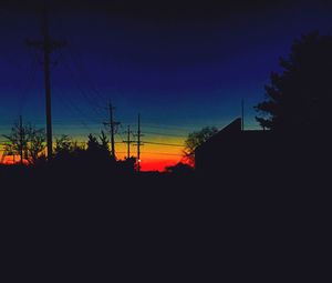 Silhouette electricity pylon against sky during sunset