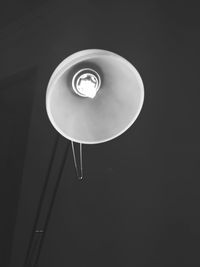 Low angle view of illuminated light bulb against black background