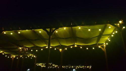 Low angle view of illuminated lighting equipment at night