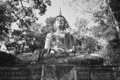 Low angle view of statue against trees