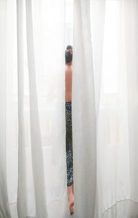 Woman seen through curtains