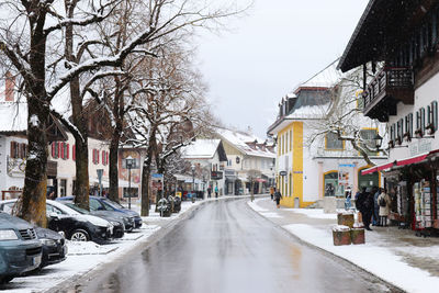 Road amidst buildings in city during winter