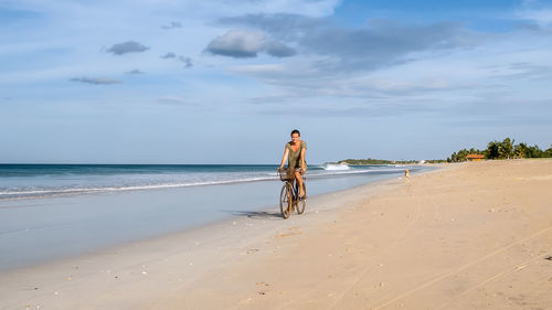 Woman riding bicycle at beach