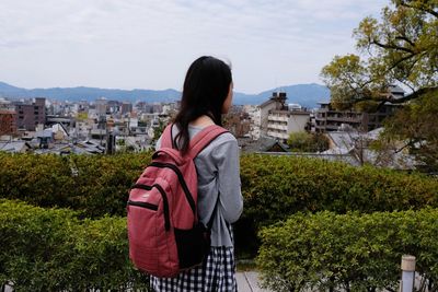 Rear view of woman looking at cityscape