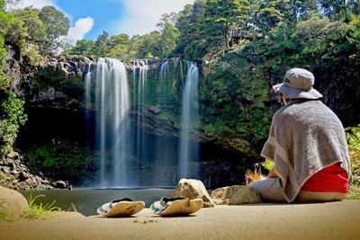 Rear view of woman looking at waterfall