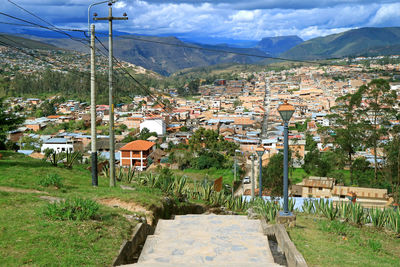 Scenic view of townscape by field against sky