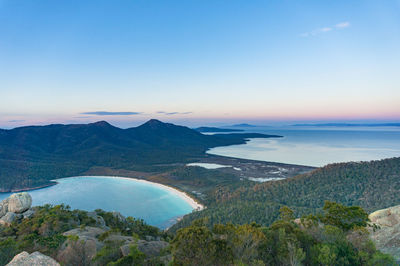 Scenic view of sea and mountains against sky