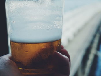 Close-up of hand holding beer glass