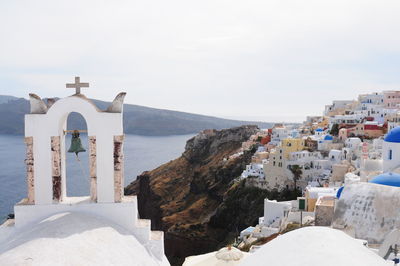 Bell tower by village at santorini against clear sky