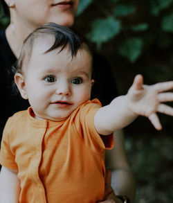 Portrait of a little beautiful caucasian baby girl in a yellow bodysuit with a cute look