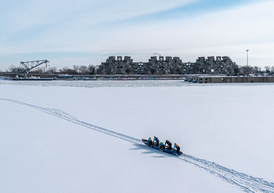 People ice canoeing on frozen river