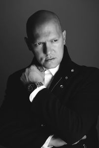 Portrait of young man standing against black background