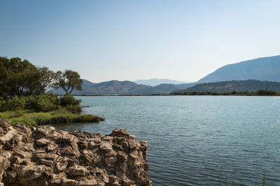 Scenic view of lake and mountains against clear sky