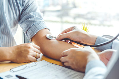 Midsection of couple holding hands on table