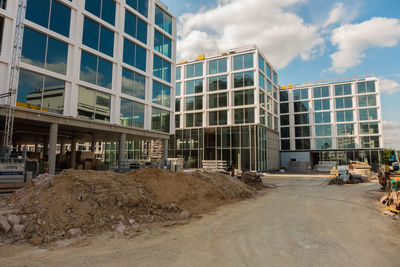 View of construction site by buildings against sky