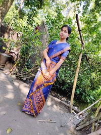 Full length of woman wearing sari standing against tree