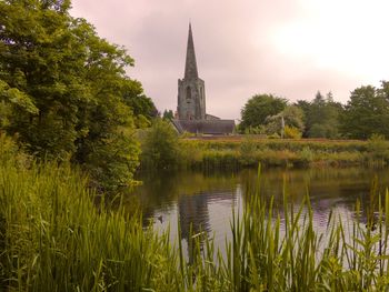 Atmospheric photo of village church across water with sky scene ...