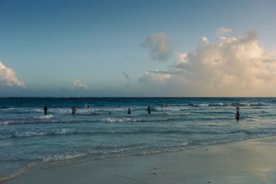 Panoramic view of people on beach against sky