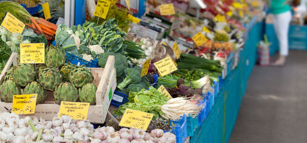 Fresh vegetables with labels on market stall