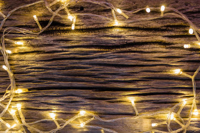 Reflection of illuminated lights on water at beach