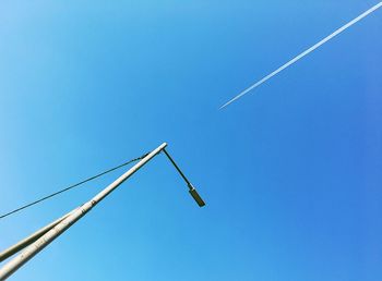 Low angle view of vapor trail against clear blue sky