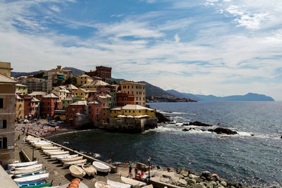 High angle view of buildings by sea against sky